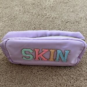 Purple Cosmetic Bag with Colorful SKIN Logo